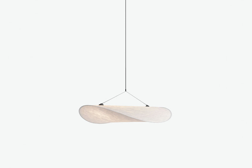 Wisząca lampa z jasnym owalnym kloszem zawieszonym na cienkich linkach.