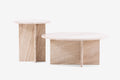 Dwa okrągłe stoliki w jasnym drewnie.