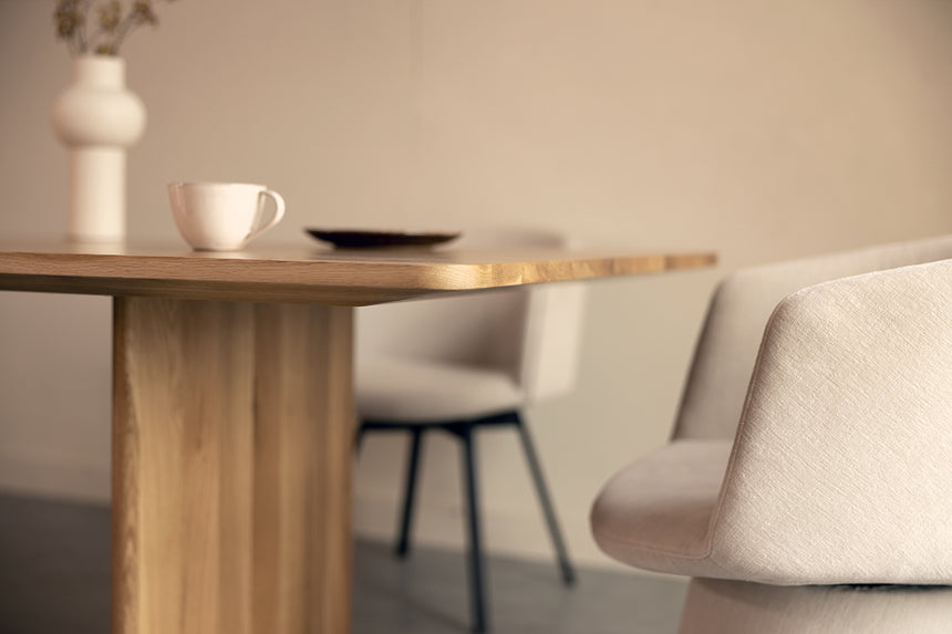 Fragment stołu, krzeseł i naczyń.