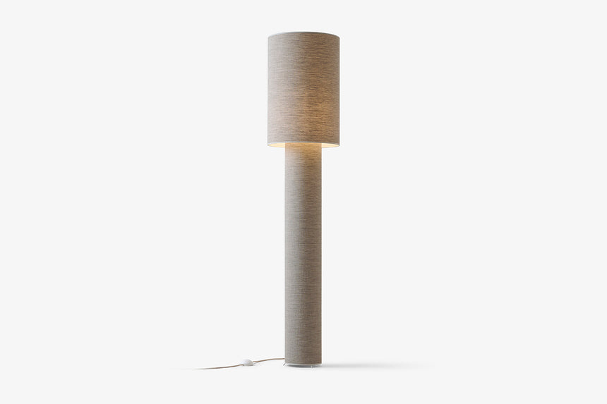 Smukła lampa podłogowa z cylindrycznym szarym abażurem.