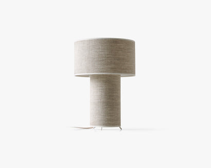 Beżowa lampa stołowa z cylindrycznym abażurem i prostą podstawą.